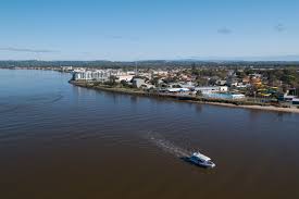 Aerial view of Ballina River and coastline with boats and town buildings, New South Wales Australia
